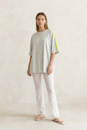 White Lace Pants with scalloped hem shown on model also wearing a grey tshirt with neon yellow stripe